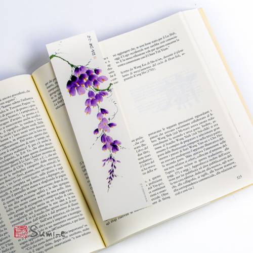 segnalibro di pittura sumi-e rappresentante il fiore di glicine su carta avorio con libro aperto